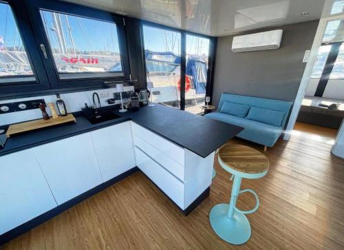多尔梅莱托HouseBoat - Lago Maggiore con Jacuzzi的厨房配有柜台、凳子和一些窗户