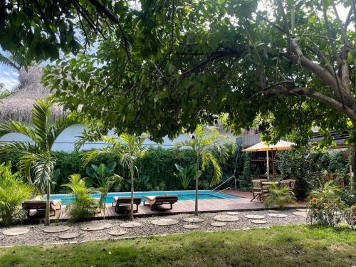 a swimming pool in a garden with a table and benches at Haku hotel in Palomino