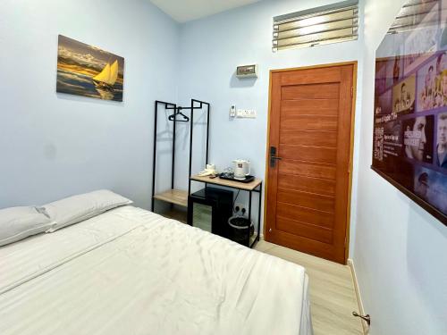 a bedroom with a bed and a wooden door at Century Sapphire - Near KSL & Holiday Plaza in Johor Bahru
