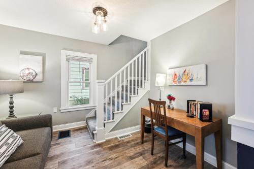 a living room with a table and a stairway at Orange Blossom House - Quaint Family Home 10 Minutes from Downtown MPLS in Minneapolis