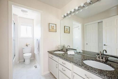 a white bathroom with two sinks and a toilet at Tiller House - Savannah Room in Windsor