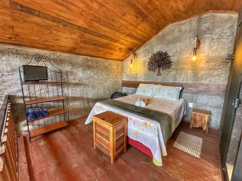 a bedroom with a bed and a tv in a room at Estância Hidromineral Serra da Canastra - Delfinópolis MG in Delfinópolis