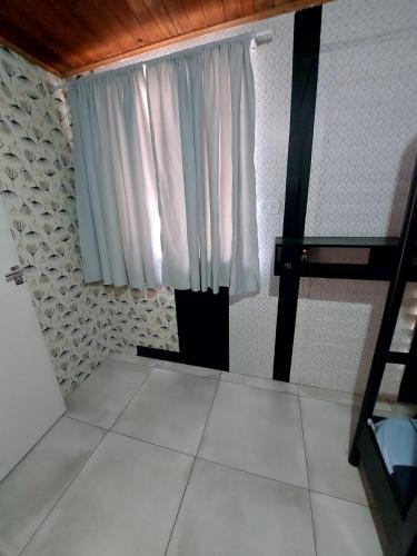 a room with a window and a white tile floor at Hotel Dom Paulo in Lapa