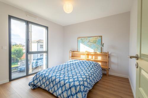a bedroom with a bed and a large window at Maison moderne et spacieuse avec jardin à Pessac in Pessac