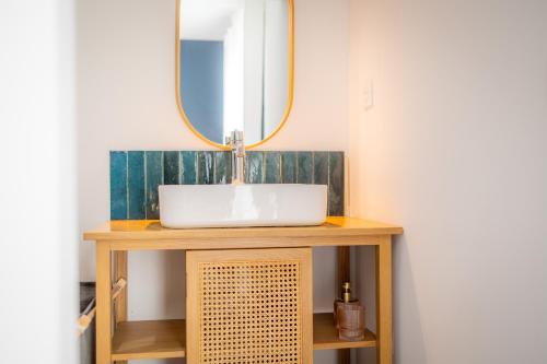 a bathroom with a sink and a mirror at Maison moderne et spacieuse avec jardin à Pessac in Pessac