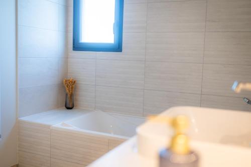 a bathroom with a tub and a vase of flowers at Maison moderne et spacieuse avec jardin à Pessac in Pessac