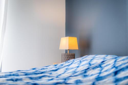 a lamp sitting on top of a bed at Maison moderne et spacieuse avec jardin à Pessac in Pessac