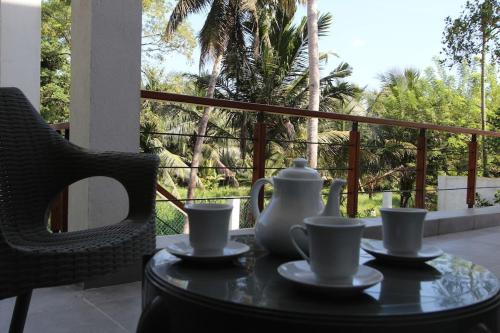 a table with a vase and cups on a balcony at The Oriole - Your base to explore Sri Lanka in Battaramulla