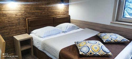 a bedroom with a bed and two pillows at Apartment Dream Konaci in Kopaonik