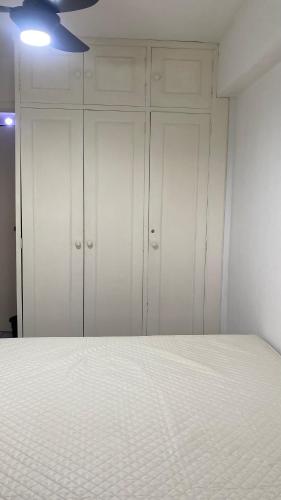 a bedroom with white cabinets and a bed at Apartamento Matteo in Ubatuba