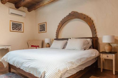 a bedroom with a large bed with a wooden headboard at Casita Azul, Historic and Cozy Santa Fe Adobe in Santa Fe