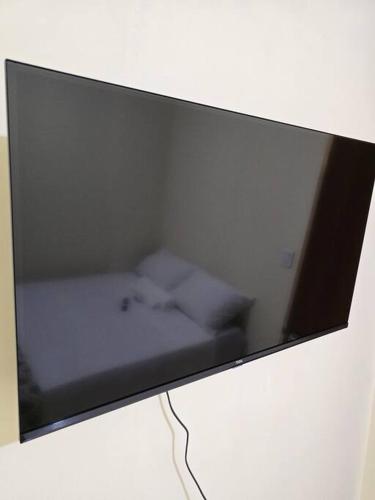 a flat screen tv on top of a wall at Edificio Hayannes - 1 Quarto - 1 Cozinha - 1 Banheiro - Garagem Coberta - Self Check in -Taxa Para Hospede Com Pets in Maringá