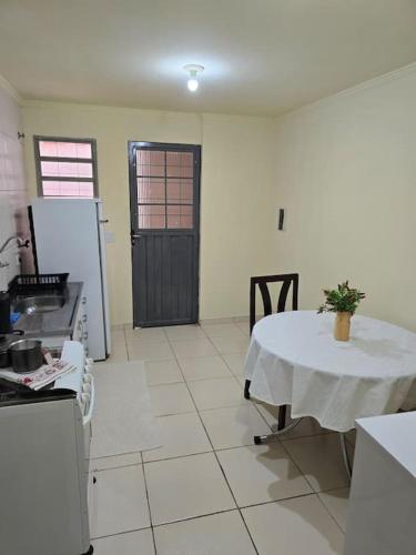 a kitchen with a table and a refrigerator at Edificio Hayannes - 1 Quarto - 1 Cozinha - 1 Banheiro - Garagem Coberta - Self Check in -Taxa Para Hospede Com Pets in Maringá