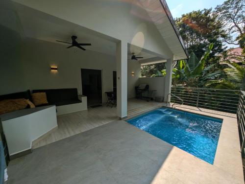 a villa with a swimming pool and a living room at The Twins Pool Villas in Cristo Rey