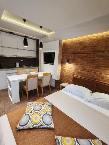 a bedroom with a large bed and a dining room at Apartment Dream Konaci in Kopaonik