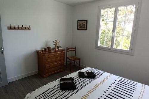 Un pat sau paturi într-o cameră la Maison calme et arboré à Cordes sur Ciel