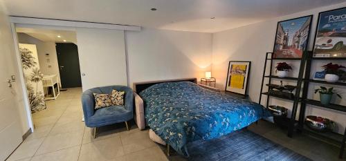 een slaapkamer met een bed en een blauwe stoel bij Maison Les Vallées in La Garenne-Colombes