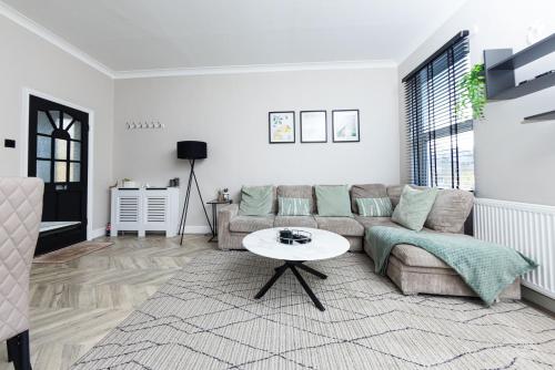 a living room with a couch and a table at Park House, Refurbed Modern Interior, Located In Finsbury Park in London