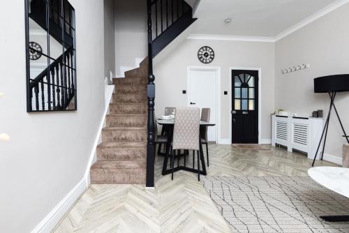 a kitchen and dining room with a table and stairs at Park House, Refurbed Modern Interior, Located In Finsbury Park in London
