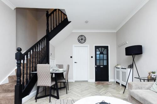 a living room with a table and chairs and a staircase at Park House, Refurbed Modern Interior, Located In Finsbury Park in London