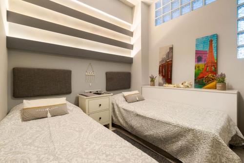 a bedroom with two beds and a painting on the wall at Diamond apartment in Athens