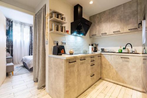 a kitchen with wooden cabinets and a bed in a room at Diamond apartment in Athens