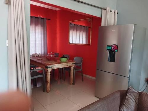 a kitchen with a table and a refrigerator at Aacron Hills Guesthouse in Kasane