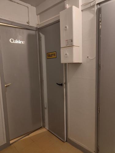 Cette chambre dispose de deux portes en métal et d'un réfrigérateur. dans l'établissement 7 rue politzer, au Blanc-Mesnil