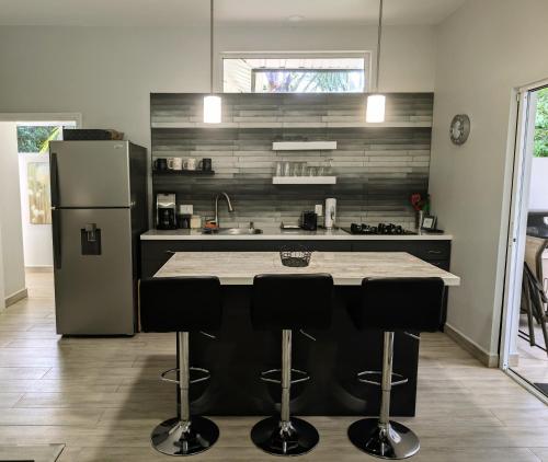 a kitchen with a counter and a refrigerator at The Twins Pool Villas in Cristo Rey
