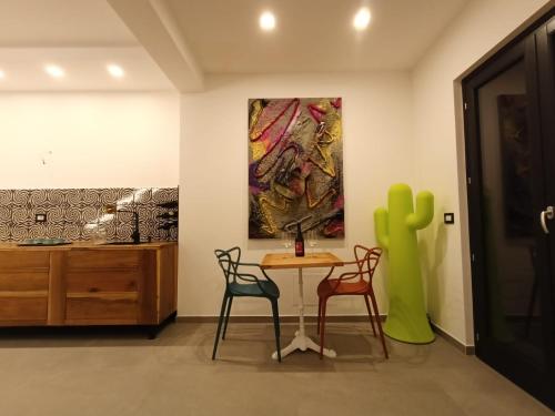 a table and chairs in a room with a painting at B&B Il Castello in Rome