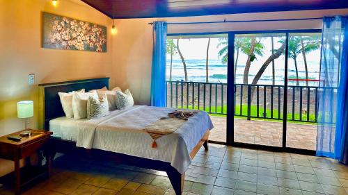 a bedroom with a bed and a view of the ocean at Hotel Beachfront Vista Hermosa in Jacó