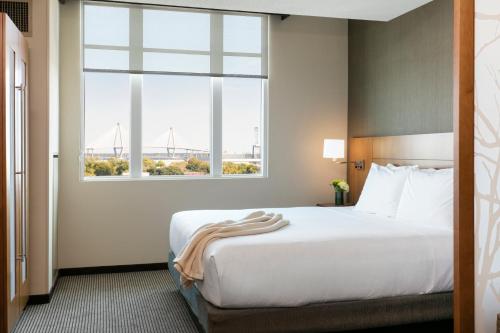 a hotel room with a bed and a large window at Hyatt Place Charleston - Historic District in Charleston