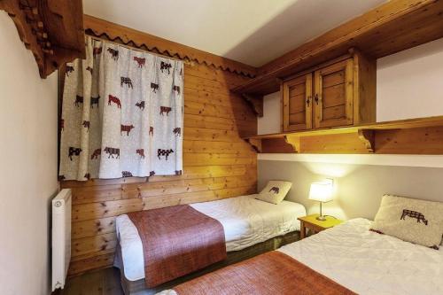 deux lits dans une chambre aux murs en bois dans l'établissement Résidence Les Hauts Bois - Résidence LES HAUTS-BOIS N°A6 MAE-5171, à Aime La Plagne