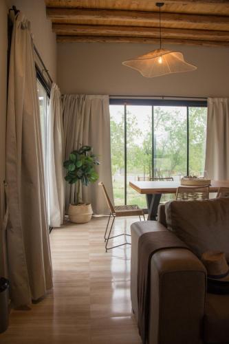 a living room with a couch and a table and windows at Blend Lodges in Tunuyán