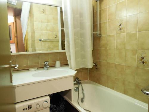 une salle de bain avec un lavabo, une baignoire et un miroir dans l'établissement Résidence La Clef - Appartement 2 pièces pour 5 personnes de 34m² MAE-0711, à La Plagne Tarentaise
