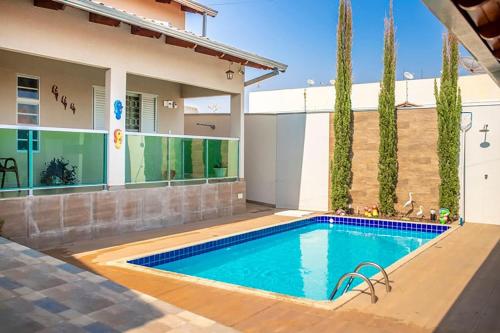 a swimming pool in front of a house at Casa c/4 quartos e Piscina - Excelente localização in Caldas Novas