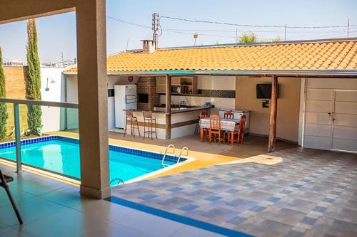 a villa with a swimming pool and a kitchen at Casa c/4 quartos e Piscina - Excelente localização in Caldas Novas