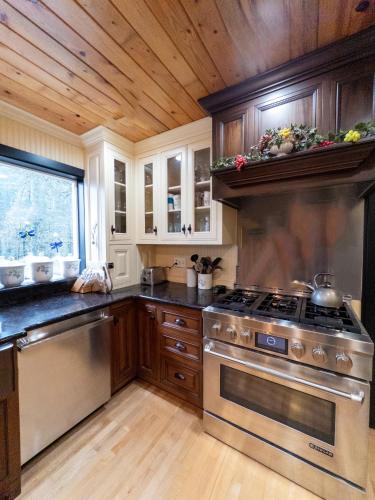a kitchen with a stainless steel stove and wooden cabinets at The Mountain House in Corvallis
