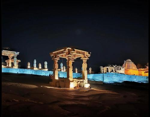 un gruppo di colonne di fronte a un edificio di notte di Reddy home stay a Hampi