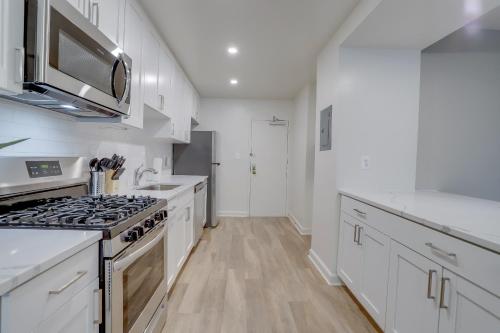 a kitchen with white cabinets and a stove top oven at Prime Location! 2BR Apartment in Crystal City in Arlington
