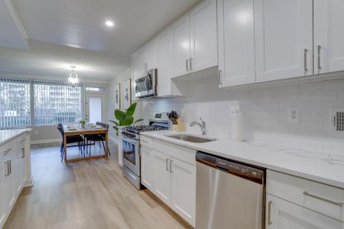a white kitchen with white cabinets and a table at Prime Location! 2BR Apartment in Crystal City in Arlington