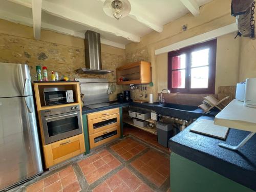 une cuisine avec un évier et un réfrigérateur dans l'établissement Gite Bimienthus te Beaumont en Perigord Dordogne, à Combe-Molière
