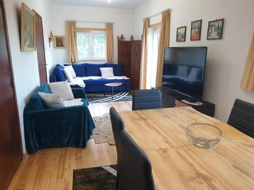 a living room with a table and a blue couch at Casa Oriana - Serra da Estrela in São Paio