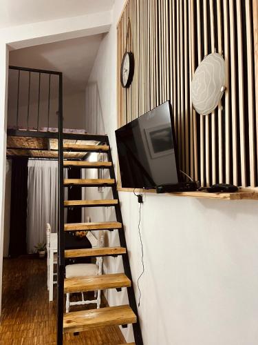 a room with a tv and a staircase with a clock at Dado in Virpazar