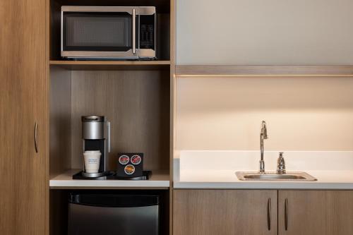 a kitchen with a microwave and a coffee maker at Microtel Inn & Suites by Wyndham Val-d Or in Val-dʼOr