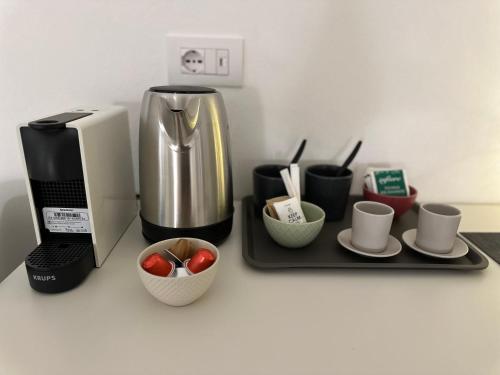 a kitchen counter with a coffee maker and coffee cups at La Casa Bianca Rooms&Lounge in Cesenatico