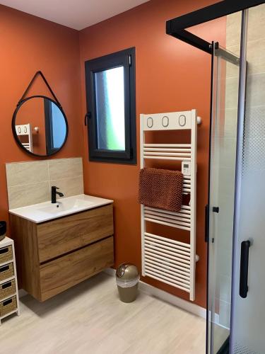 a bathroom with a sink and a mirror at Gîtes Rozanna avec accès détente SPA JACUZZI in Saint-Jean-de-la-Rivière