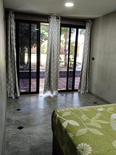 a bedroom with a bed and sliding glass doors at Casa Lomas Grangelo in Atlixco