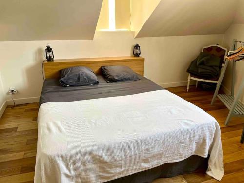 une chambre avec un lit avec deux oreillers dessus dans l'établissement Adorable petite maison indépendante avec parking privé, à Le Mesnil-le-Roi