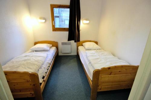 deux lits jumeaux dans une chambre avec fenêtre dans l'établissement Chalets De La Vanoise - LES CHALETS DE LA VANOISE-CV3103 MAE-4531, à Villarodin-Bourget
